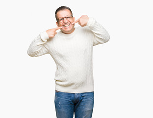 Fototapeta premium Middle age arab man wearing glasses over isolated background smiling confident showing and pointing with fingers teeth and mouth. Health concept.
