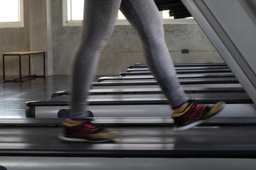 Fitness woman in leging sportware walking on treadmill machine