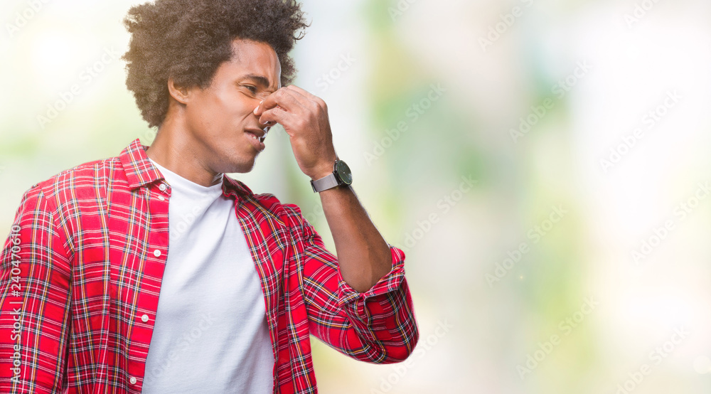 Sticker afro american man over isolated background smelling something stinky and disgusting, intolerable sme