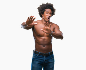 Fototapeta premium Afro american shirtless man showing nude body over isolated background afraid and terrified with fear expression stop gesture with hands, shouting in shock. Panic concept.