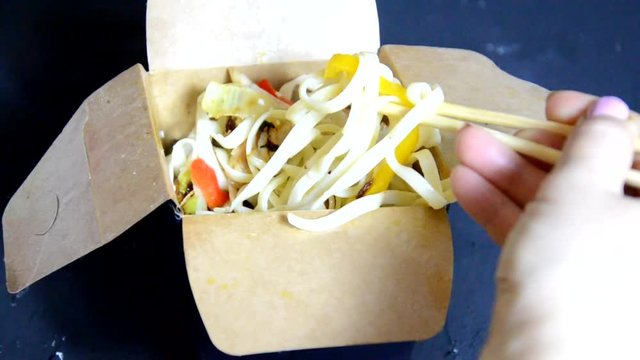 Korean noodles in cardboard box take out on dark background