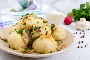 Ukrainian dumplings with meat and mushrooms in a bowl on a white background.