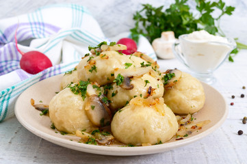 Ukrainian dumplings with meat and mushrooms in a bowl on a white background.