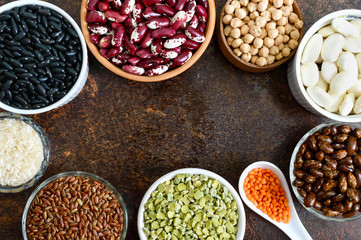 Healthy food, dieting, nutrition concept, vegan protein source. Assortment of colorful raw legumes: lentils, green peas, beans, chickpeas, rice in bowls. Background. Free space.