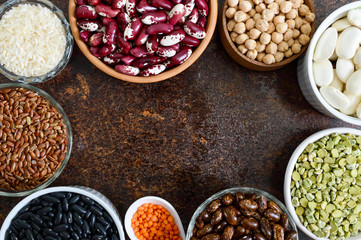 Healthy food, dieting, nutrition concept, vegan protein source. Assortment of colorful raw legumes: lentils, green peas, beans, chickpeas, rice in bowls. Background. Free space.