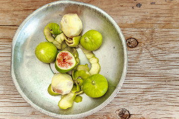 Peeled, ripe figs on silver bowl