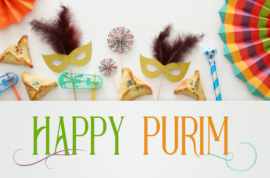Purim celebration concept (jewish carnival holiday) over white wooden background. Top view
