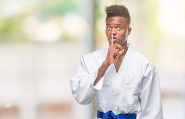 Young african american man over isolated background wearing kimono asking to be quiet with finger on lips. Silence and secret concept.