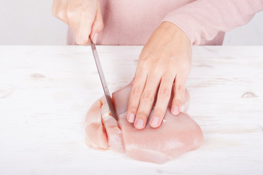 Female Hands Cutting Chicken Fillet