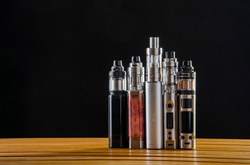 Popular vaping e cig devices mod.electronic cigarette over a black background. vaporizer e-cig old...