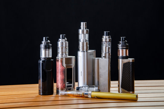 Popular vaping e cig devices mod.electronic cigarette over a black background. vaporizer e-cig old device model. pen cigarette