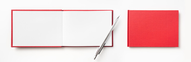 Top view of red hardcover notebook and pencil