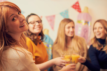 Pregnant woman celebrating baby shower party with friends.