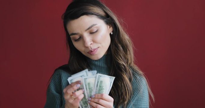 Atractive beautiful brunette woman count money and think about how to spend them.