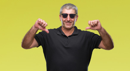 Naklejka premium Handsome senior man wearing sunglasses over isolated background looking confident with smile on face, pointing oneself with fingers proud and happy.
