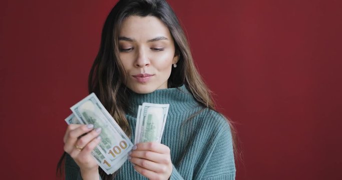 Atractive beautiful brunette woman count money and think about how to spend them.