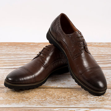 Men's brown shoes on a wooden background