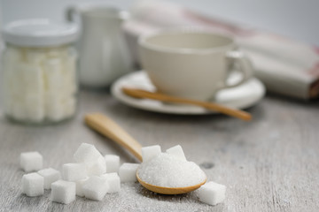 Fototapeta na wymiar Sugar in wooden spoon for putting in coffee, adding sweetness - image