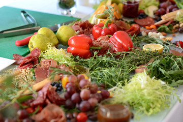 assorted cheeses, jamon and sausages with pickles and olives, on wooden boards
