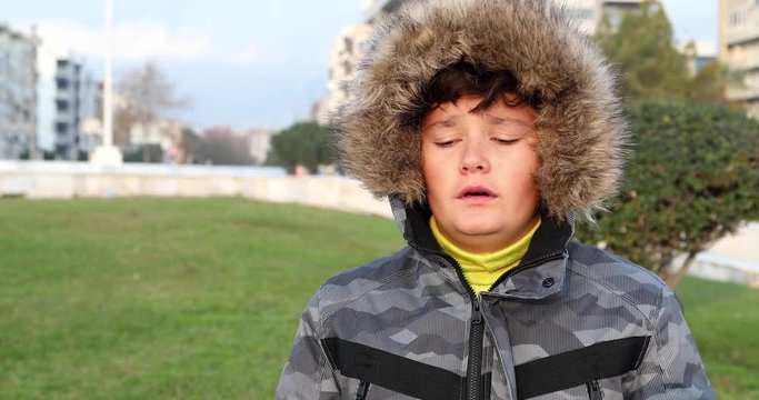 Preteen boy having a cold and flu virus outdoors 2