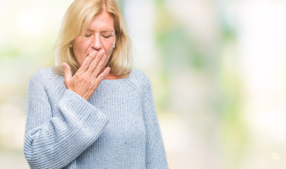 Middle age blonde woman wearing winter sweater over isolated background bored yawning tired covering mouth with hand. Restless and sleepiness.
