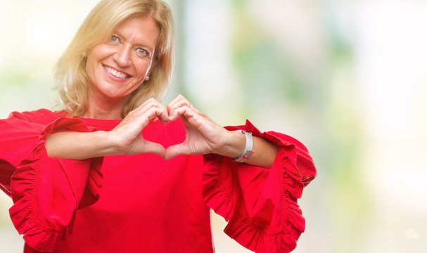 Middle age blonde woman over isolated background smiling in love showing heart symbol and shape with hands. Romantic concept.