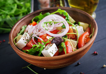 Greek salad with fresh tomato, cucumber, red onion, basil, feta cheese, black olives and Italian herbs