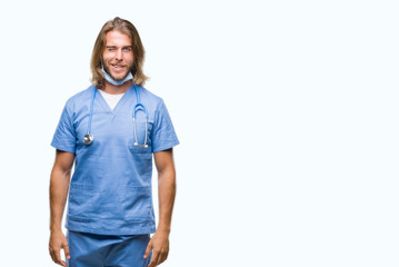 Fototapeta premium Young handsome doctor man with long hair over isolated background winking looking at the camera with sexy expression, cheerful and happy face.