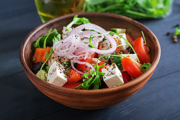 Greek salad with fresh tomato, cucumber, red onion, basil, feta cheese, black olives and Italian herbs