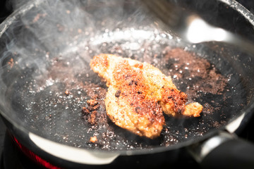 Schnitzel cooking in a pan.