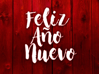 szczęśliwego nowego roku na czerwonym tle z desek po hiszpańsku
