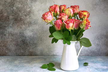 Bouquet of pink roses in a white vintage pitcher or jug.