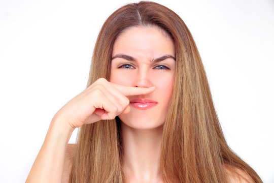 Gorgeous woman crits her face with her index finger under her nose