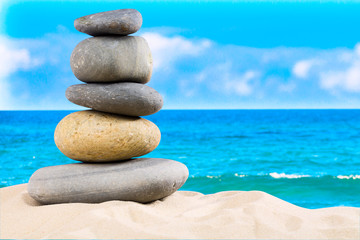 Fototapeta na wymiar Zen rock, concept of harmony and balance. Zen stones pyramid on the beach with amazing turquoise blue water sea and sky