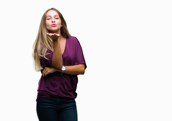 Young beautiful blonde elegant woman over isolated background looking at the camera blowing a kiss with hand on air being lovely and sexy. Love expression.