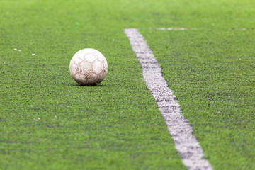 Ball on the green grass of a football field