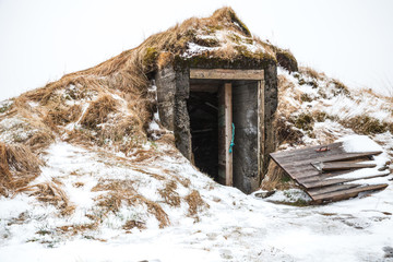 Old cellar with broken door, Iceland