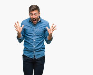 Young handsome man over isolated background celebrating crazy and amazed for success with arms raised and open eyes screaming excited. Winner concept