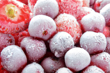 Closeup of frozen mixed fruits, berries - red currant, cherry, strawberry. Background, texture of frozen fruit.