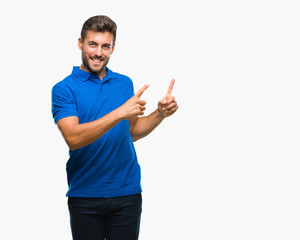 Young handsome man over isolated background smiling and looking at the camera pointing with two hands and fingers to the side.