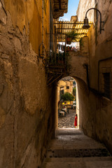 Fototapeta na wymiar Girl stands under the arch in the old baroque town Modica in Sicily, Italy
