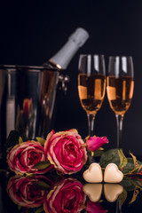 Champagne bottle with two wine glasses and  bouquet of rosses