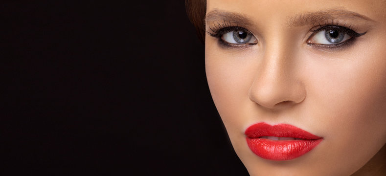 close-up portrait of model on a dark background. Beautiful woman portrait, beauty on dark background. bright red lips and heavily made-up eyelids. space for text and copy-paste.