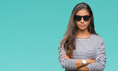Young beautiful arab woman wearing sunglasses over isolated background skeptic and nervous,...