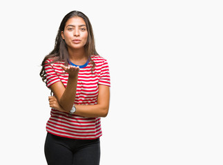 Young beautiful arab woman over isolated background looking at the camera blowing a kiss with hand on air being lovely and sexy. Love expression.