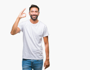 Adult hispanic man over isolated background smiling positive doing ok sign with hand and fingers. Successful expression.