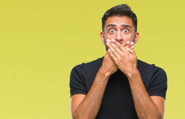 Adult hispanic man over isolated background shocked covering mouth with hands for mistake. Secret concept.