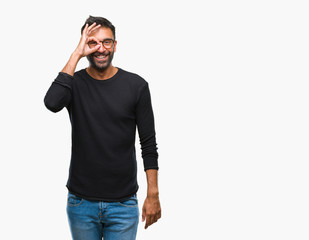 Fototapeta premium Adult hispanic man wearing glasses over isolated background doing ok gesture with hand smiling, eye looking through fingers with happy face.