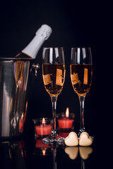 Champagne bottle, two wine glasses,chocolates heart and candles