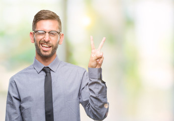 Young handsome business man over isolated background smiling with happy face winking at the camera doing victory sign. Number two.
